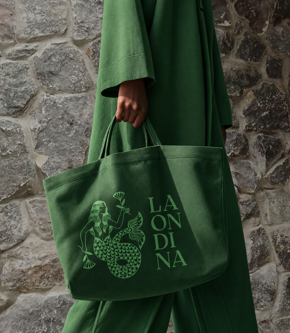 Emerald La Ondina tote bag carried against stone